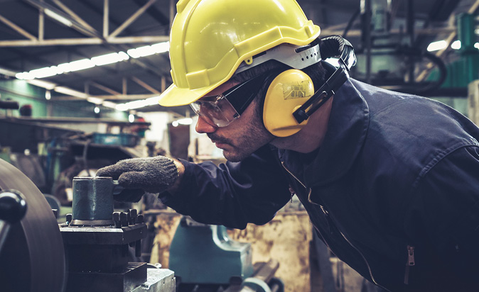 Worker with hearing protection in noisy environment